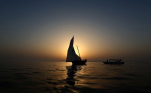 A dhow is seen at sunset during a training session on May 22, 2015 in the waters off the island of Sir Bu Nair on the eve of the Al-Gaffal 60 foot Traditional Dhow Sailing Race, in which boats will set sail off the island near the Iranian coast, until they reach the finish line at the Burj Al-Arab in Dubai. The 25th annual dhow sailing race has a total prize money of 10 million dirhams ($272,000). AFP PHOTO / MARWAN NAAMANI